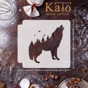 May include: A white plastic stencil featuring a silhouette of a wolf howling at the moon. The wolf is surrounded by trees and birds. The stencil measures 12.7 cm wide and 12.7 cm tall. Kato Baking Supplies is printed at the top of the stencil.