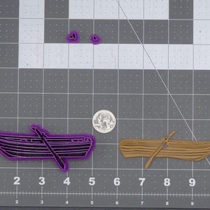 May include: Two cookie cutters, one shaped like a rowboat with an oar and the other shaped like a canoe with an oar. Both cutters are purple.