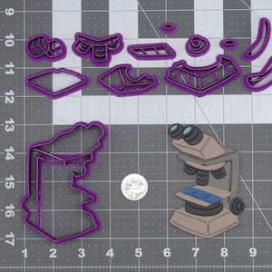 Puede incluir: Cortadores de galletas de plástico morado en forma de microscopio, portaobjetos y otras formas con temática científica. Los cortadores están sobre un fondo de cuadrícula gris.