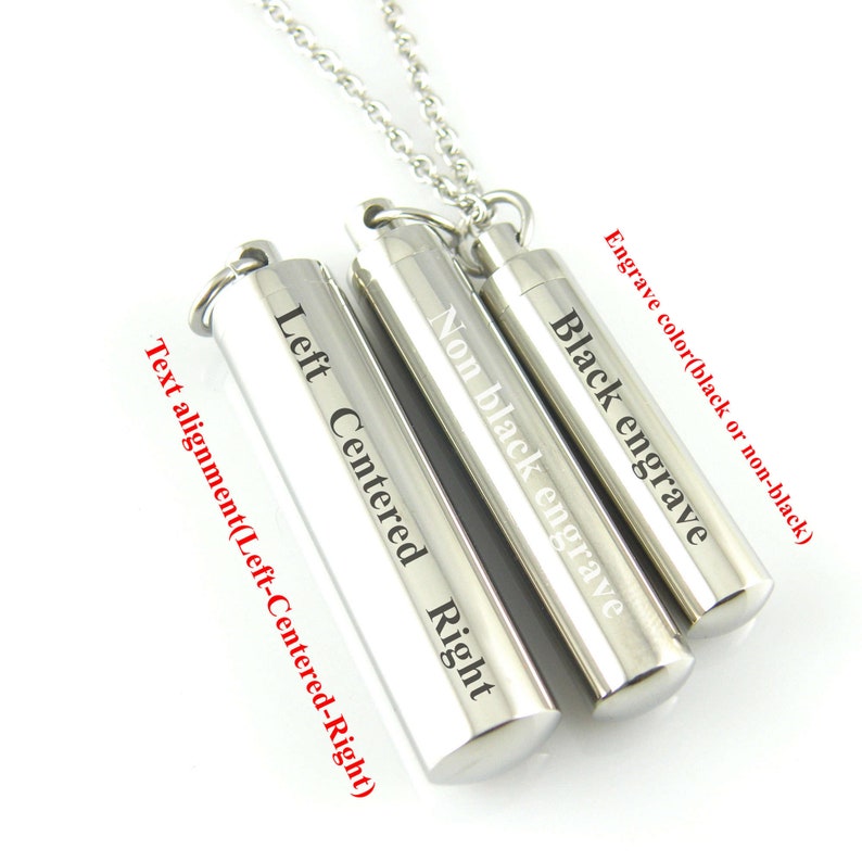 May include: Three silver cylindrical pendants on a silver chain. The pendants are engraved with the text "Black engrave", "Non black engrave", and "Left Centered Right". The text alignment options are listed below the pendants: "Text alignment (Left-Centered-Right)".