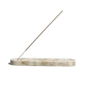 May include: A light beige oval marble incense holder with a single incense stick burning.