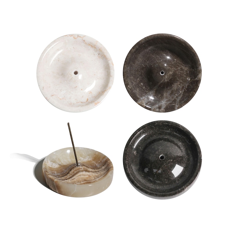 May include: Four round marble incense holders in different colors and patterns. The holders have a small hole in the center for incense sticks.