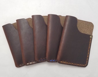 May include: Five brown leather card holders with different colored stitching. The card holders are arranged in a semi-circle with the stitching facing the viewer.
