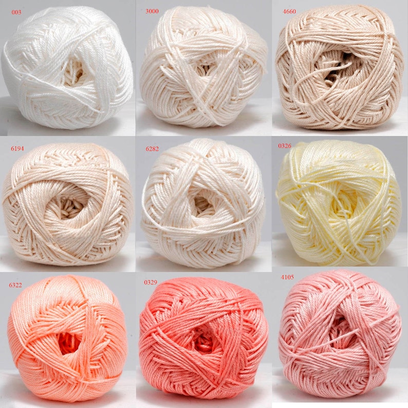 May include: Nine balls of yarn in various colors, including white, cream, peach, and pink. Each ball has a different number printed on it. The yarn appears to be a soft, smooth texture, suitable for knitting or crocheting projects.