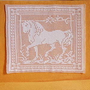 May include: A white, square, crocheted doily featuring a horse design. The horse is in the center of the doily, surrounded by floral elements. The doily has a detailed border and is set against a yellow background.