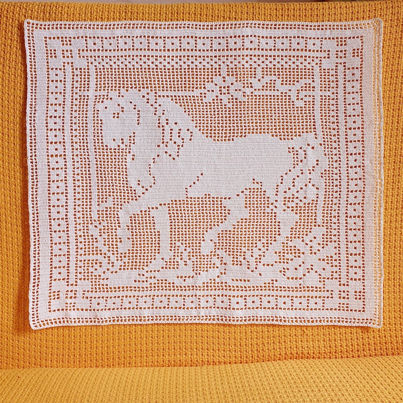 May include: A white, square, crocheted doily featuring a horse design. The horse is in the center of the doily, surrounded by floral elements. The doily has a detailed border and is set against a yellow background.