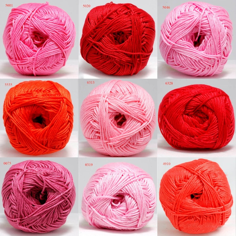 May include: Nine balls of yarn in various shades of pink, red, and orange. The yarn balls are arranged in a grid, with each ball displaying a different color and shade. The yarn is tightly wound, and the texture appears soft and smooth.