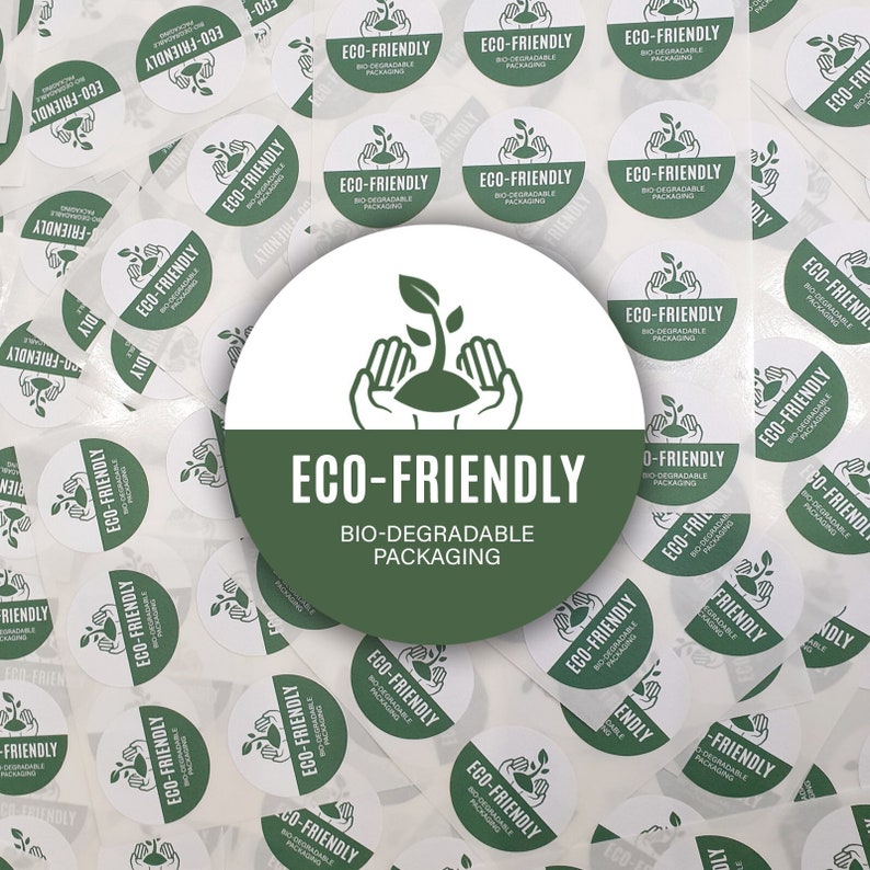 May include: A close-up of a white circle sticker with green text that reads "ECO-FRIENDLY BIO-DEGRADABLE PACKAGING". The sticker has a green sprout and two hands holding the sprout. The sticker is surrounded by many other white circle stickers with the same text and design.