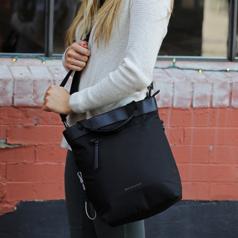 Over model's shoulder is Sherpani Anti-Theft bag, the Geo AT in Carbon.