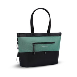 Angled front view of Sherpani Anti-Theft tote, the Cali AT in Teal, with vegan leather accents in black. There is an external compartment on the front of the bag with a locking zipper.