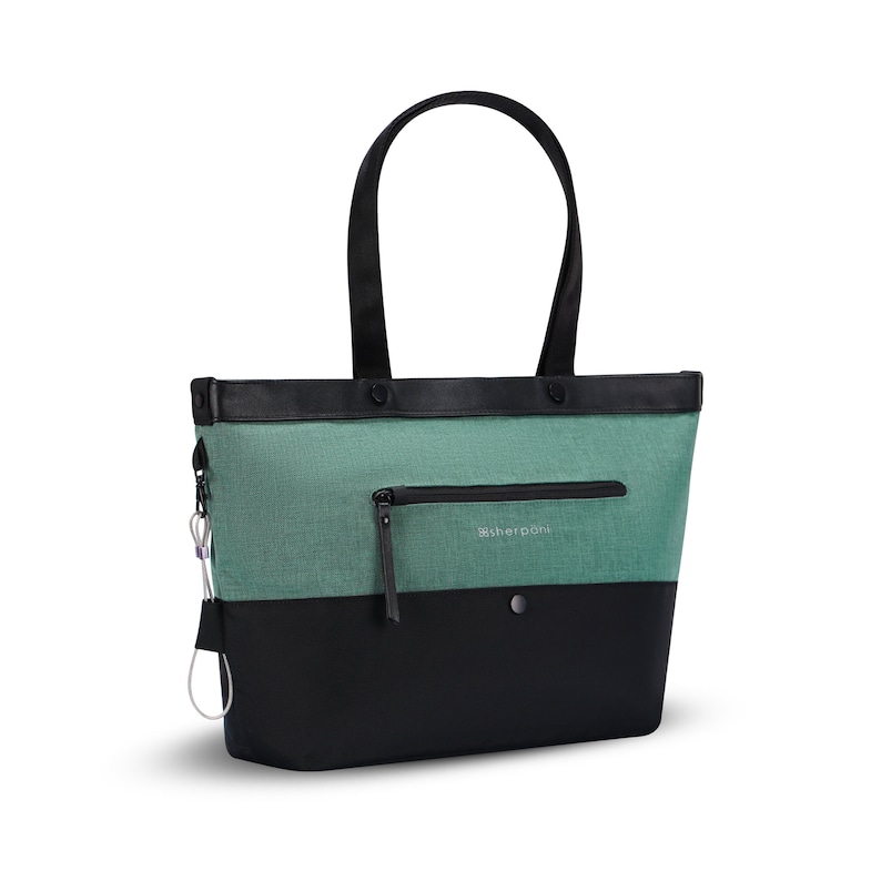 Angled front view of Sherpani Anti-Theft tote, the Cali AT in Teal, with vegan leather accents in black. There is an external compartment on the front of the bag with a locking zipper.