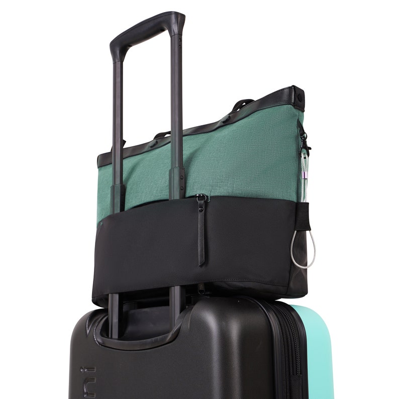 Back view of Sherpani Anti-Theft bag the Cali AT in Teal. The exterior zipper pocket is unzipped at both ends creating the luggage pass-through.