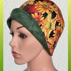 May include: A green and black fabric hat with a sunflower print. The hat has a wide brim and is made of a soft, comfortable material.