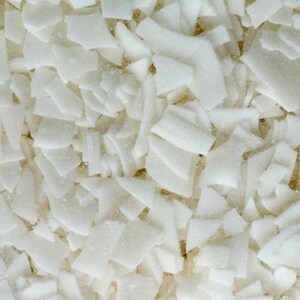 Puede incluir: Primer plano de trozos blancos de coco en escamas de forma irregular.