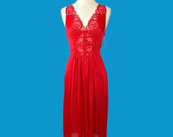 May include: A bright red sleeveless nightgown featuring a deep V-neckline adorned with intricate floral lace trim. The bodice includes a central vertical panel of matching red lace, while the skirt falls in a smooth, flowing silhouette.