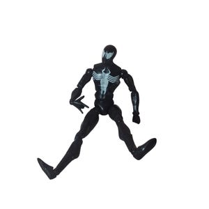 Peut inclure: Figurine d'action noire repr&eacute;sentant un super-h&eacute;ros dans une pose dynamique. La figurine arbore un embl&egrave;me d'araign&eacute;e blanc sur la poitrine et un motif en forme d'araign&eacute;e blanc sur la t&ecirc;te. Les membres sont articul&eacute;s.