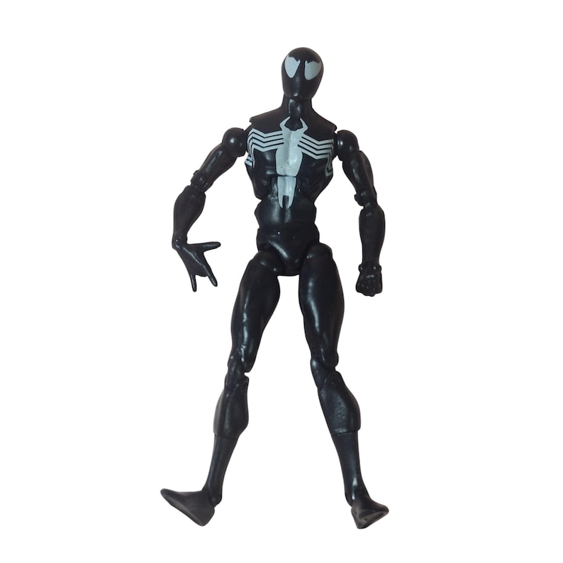 Peut inclure: Figurine d'action noire d'un super-h&eacute;ros avec un embl&egrave;me d'araign&eacute;e blanc sur la poitrine et le dos. La figurine a des articulations articul&eacute;es et est pos&eacute;e avec une main tendue. C'est un jouet de collection.