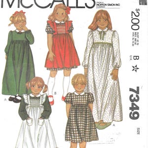 May include: McCall's sewing pattern featuring illustrations of girls' dresses. The dresses include a green long-sleeve dress, a red dress with a white collar, and a white dress with a floral pattern. The pattern is size 6.