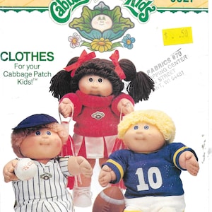 May include: Vintage Butterick sewing pattern for Cabbage Patch Kids clothes. The pattern features three Cabbage Patch Kids dolls dressed in a baseball uniform, cheerleader outfit, and football uniform. The pattern number is 6827.