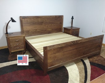 May include: A dark wood bed frame with a headboard and footboard. The bed frame is made of solid wood and has a natural finish. The bed frame is sitting on a rug with a brown, black, and white pattern. The bed frame is made in the U.S.A.