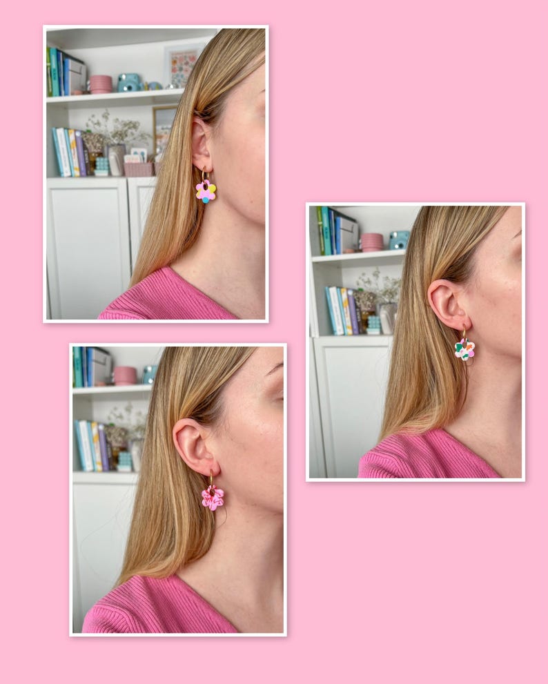 Op de afbeelding: Gouden oorringen met bloemvormige hangers in roze, geel, blauw en groen. De oorbellen worden getoond aan een oor, tegen een roze achtergrond.