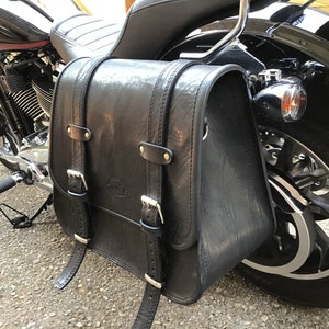 Può includere: Selle laterali in pelle nera per moto con fibbie e cinghie attaccate a una moto nera.