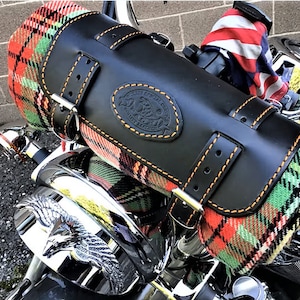 Può includere: Una borsa da sella per moto in pelle nera con cuciture arancioni e una coperta a quadri all'interno. La borsa ha una toppa in pelle con il testo "The Leather Works Co. Handcrafted in USA".