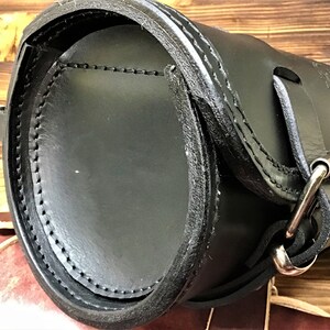 Può includere: Sella da moto in pelle nera con chiusura a fibbia e dettagli di cucitura.