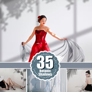 May include: A woman in a red strapless dress with black lace detailing and a flowing skirt. The dress is paired with a red flower in her hair. The image includes the text "35 Botanic Shadows".