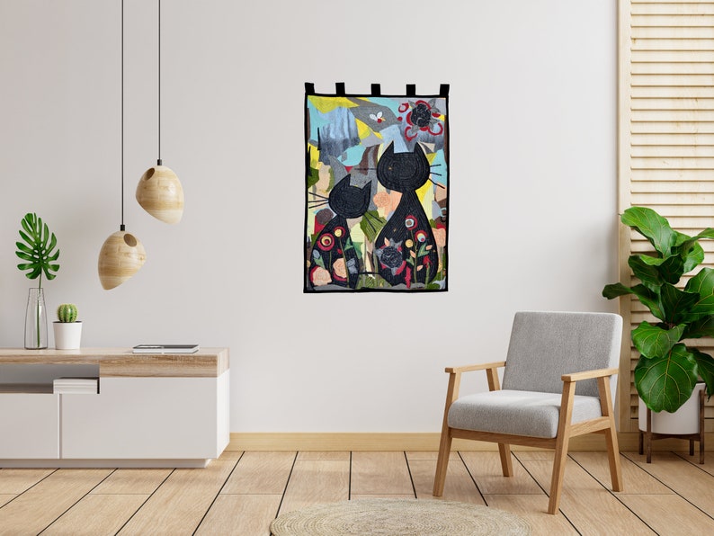 Pode incluir: Uma tape&ccedil;aria decorativa de parede com duas silhuetas de gatos pretos sobre um fundo abstrato colorido. Os gatos s&atilde;o adornados com padr&otilde;es florais. A obra de arte &eacute; emoldurada com uma borda preta e inclui la&ccedil;os para pendurar.