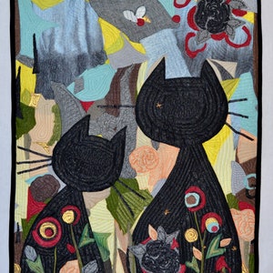 Pode incluir: Uma obra de arte t&ecirc;xtil colorida com duas silhuetas de gatos pretos. A obra &eacute; composta por formas abstratas em tons de azul, amarelo, cinza e verde, com detalhes florais em vermelho e p&ecirc;ssego. A obra &eacute; emoldurada com uma borda preta.