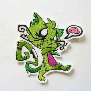 Peut inclure: Chat de dessin animé vert cousu avec une cravate rose et une bulle de pensée au-dessus de sa tête contenant un cerveau rose.