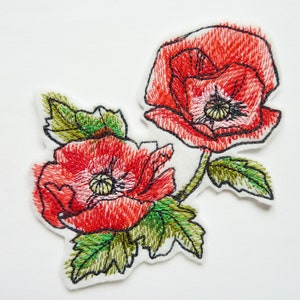 Peut inclure: Patch brodé de fleurs de pavot avec deux pavots rouges et des feuilles vertes.