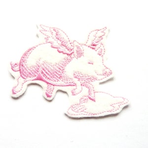 Puede incluir: Parche de hierro bordado rosa de un cerdo con alas volando sobre una nube.