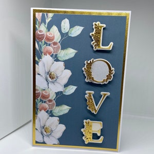 L-37 Tarjeta de felicitación de amor. Letras decoupage en crema y oro montadas sobre tarjeta de flores. En blanco para que agregues tu propio mensaje. san valentin