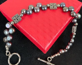 Pulsera vintage de plata de ley con perlas grises y cierre de palanca. Probada en plata.