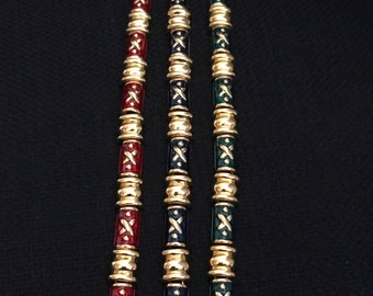 May include: Three gold bracelets with enamel detailing. The bracelets are red, blue, and green.