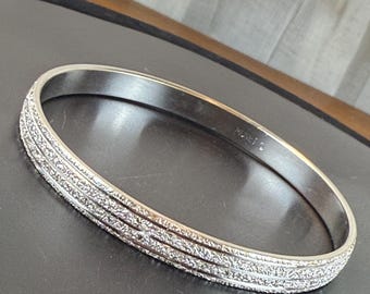 Pulsera rígida vintage Monet en tono plateado, diseño texturizado de triple cresta, década de 1980.
