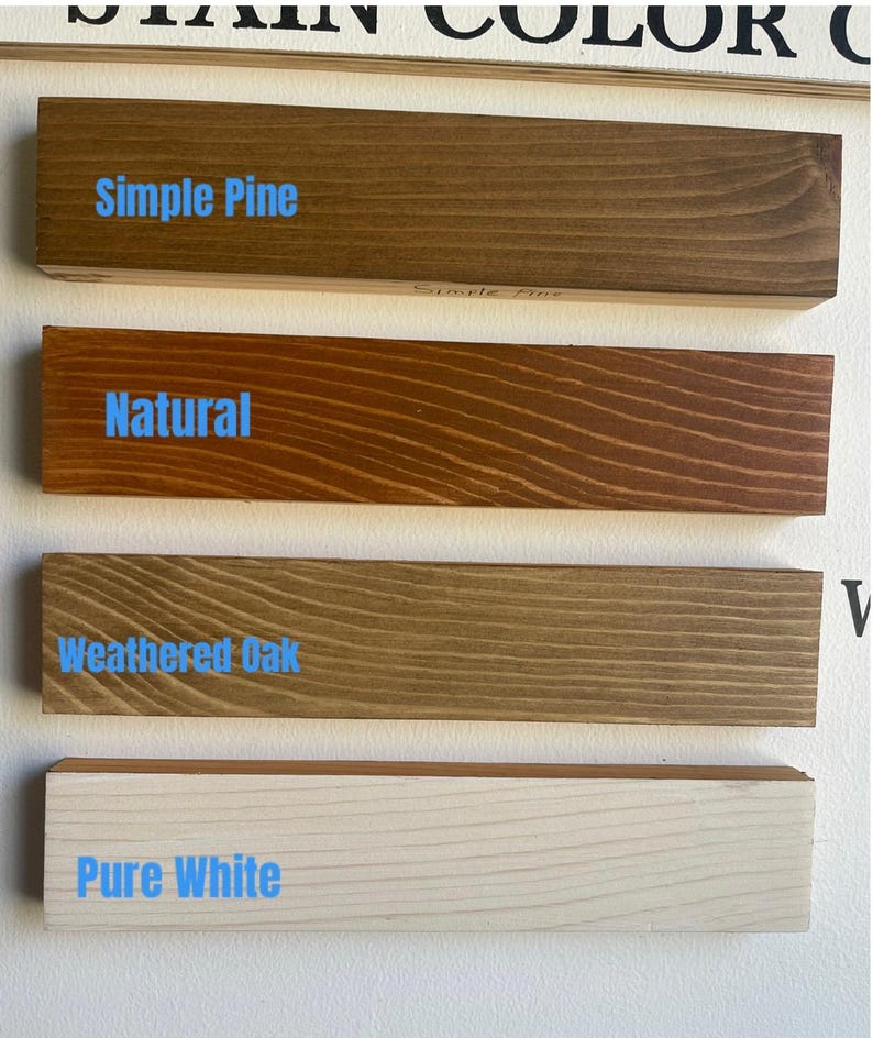 K&ouml;nnte beinhalten: Vier Holzbretter mit Beispielen f&uuml;r Beizfarben: Simple Pine, Natural, Weathered Oak und Pure White. Jedes Brett zeigt die Holzmaserung und den Namen der Beize in blauem Text. Die Bretter sind horizontal vor einem wei&szlig;en Hintergrund angeordnet.