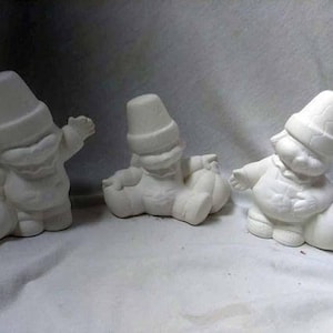 May include: Three white ceramic figurines of people wearing pilgrim hats and holding pumpkins. The figurines are in various poses and are ready to be painted.