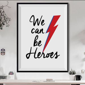 May include: A black and white print with the text "We can be Heroes" and a red and blue lightning bolt graphic.