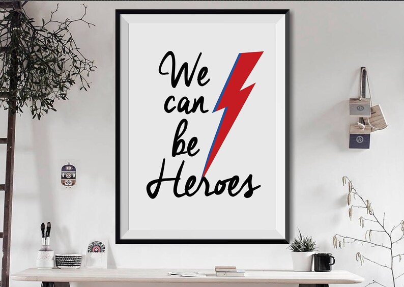May include: A black and white print with the text "We can be Heroes" and a red and blue lightning bolt graphic.