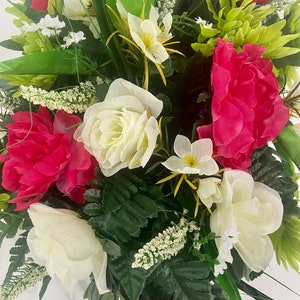 May include: A bouquet of artificial flowers with white roses, pink peonies, and green foliage.
