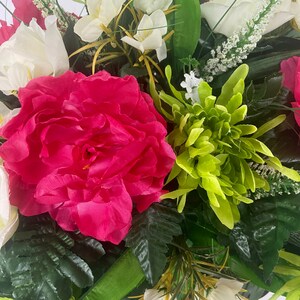 May include: A bouquet of artificial flowers in shades of pink, white, and green. The bouquet features a large pink peony, white roses, and green chrysanthemums.