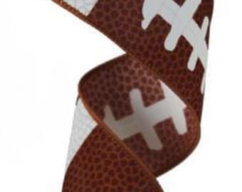 May include: A roll of decorative ribbon featuring a football design. The ribbon has a brown background with white panels and football graphics. The ribbon is ideal for crafting and decorating.