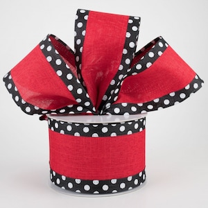 May include: Red and black polka dot ribbon with a black border. The ribbon is on a spool and is ready to be used for crafting or decorating.