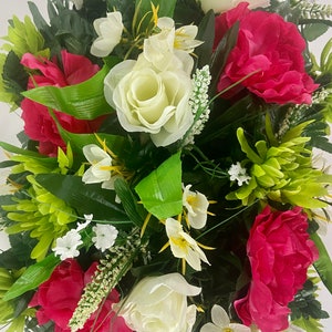 May include: A bouquet of artificial flowers with white roses, pink peonies, and green foliage.