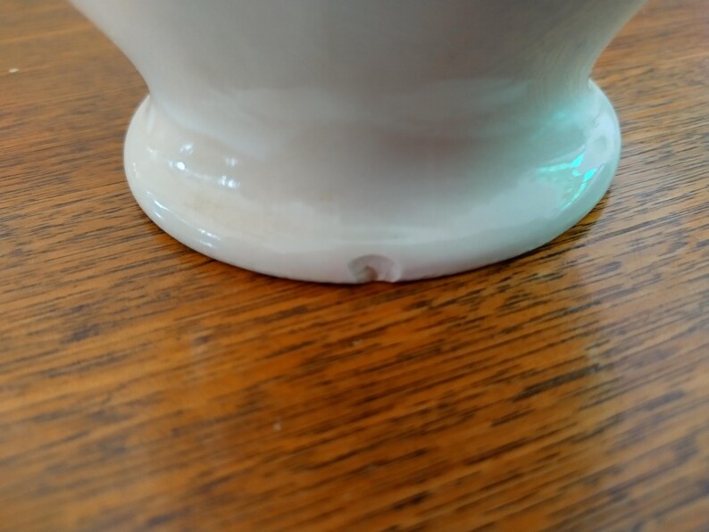 以下が含まれることがあります： 縁に小さな欠けがある白い陶器の花瓶の底