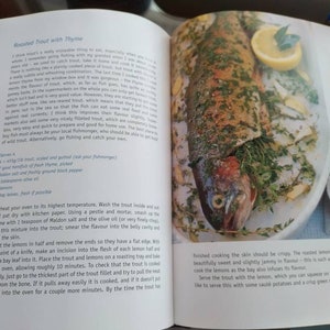 Puede incluir: Una trucha asada con tomillo, lim&oacute;n y hojas de laurel en un plato blanco. La trucha est&aacute; cocinada y tiene una piel crujiente. Los limones est&aacute;n asados y tienen una textura confitada. La receta es para trucha asada con tomillo.