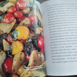 Puede incluir: Una imagen de primer plano de un taz&oacute;n de verduras asadas. Las verduras incluyen alcachofas, tomates cherry, pimientos amarillos y hierbas. El texto "Slow-cooked Artichokes, Sweet Cherry Tomatoes, Thyme and Basil" es visible en la esquina inferior izquierda de la imagen.